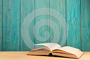 Open book on the desk over wooden background