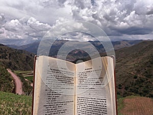 Open book in the foreground with clouds in the background