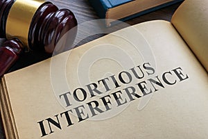 Open book and gavel. Tortious interference concept. photo