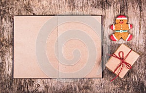 Open book, gingerbread man and gift box. Christmas surprise. Festive backgrounds.