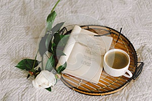 Open book with glasses, cup coffee and bouquet white pink peonies flowers