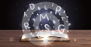 Open book with glowing letters flying out