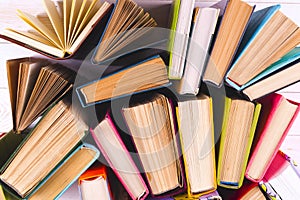 Open book, hardback books on bright colorful background.