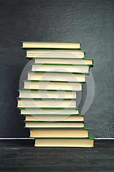 Open book, hardback books on wooden table, on a blackboard background. Back to school. Copy space for text. Education background