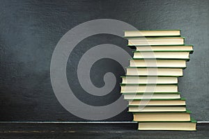 Open book, hardback books on wooden table, on a blackboard background. Back to school. Copy space for text. Education background