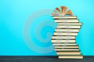 Open book, hardback books on wooden table, on a blue background. Back to school. Copy space for text. Education background