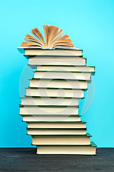 Open book, hardback books on wooden table, on a blue background. Back to school. Copy space for text. Education background