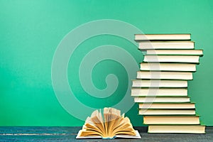 Open book, hardback books on wooden table, on a green background. Back to school. Copy space for text. Education background