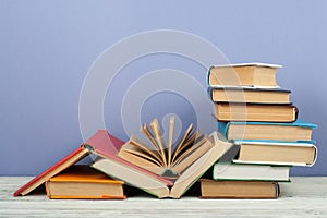 Open book, hardback colorful books on wooden table. Back to school. Copy space for text. Education business concept.