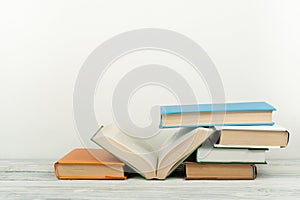 Open book, hardback colorful books on wooden table. Back to school. Copy space for text. Education business concept