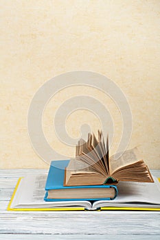 Open book, hardback colorful books on wooden table. Back to school. Copy space for text. Education business concept.