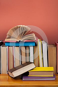 Open book, hardback colorful books on wooden table. Back to school. Copy space for text. Education business concept.