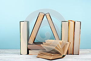 Open book, hardback colorful books on wooden table, blue background. Back to school. Copy space for text. Education