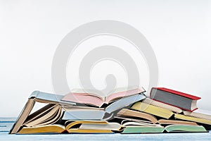 Open book, hardback colorful books on wooden table , white Background. Back to school. Copy space for text. Education business