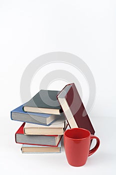 Open book, hardback colorful books on wooden table, white background. Back to school. Cup. Copy space for text