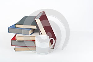 Open book, hardback colorful books on wooden table, white background. Back to school. Cup. Copy space for text