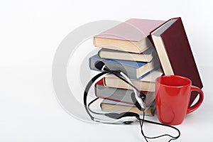 Open book, hardback colorful books on wooden table, white background. Back to school. Headphones, cup. Copy space for