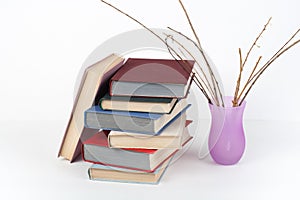Open book, hardback colorful books on wooden table, white background. Back to school. Vase Copy space for text
