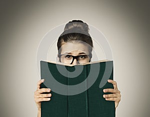 Open Book Hiding Face, Woman Eyes Reading in Glasses on Gray