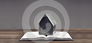 Open book. Holy Bible. Scripture. Miniature house on the book. On wooden table background