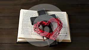 Open book holy bible on a wooden table. Scripture. Wooden cross of Jesus and red heart.