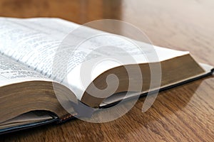 Open book Holy Bible on yellow wooden background