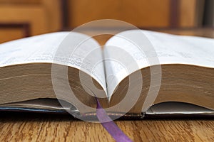 Open book Holy Bible on yellow wooden background