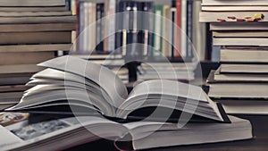 Open Book In Library full of stacks of books.