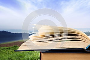 Open book over the landscape background