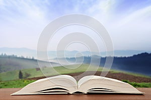 Open book over the landscape background