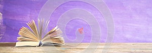 Open book on purple grungy background, reading, education, literature,panorama