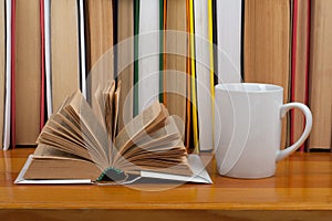 Open book, red cup hardback colorful books on wooden table. Back to school. Copy space for text. Education business concept.