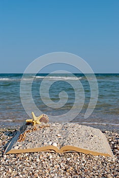 Open book sand seashells sea star beach sea shore blue sky white wave summer weekend vacation