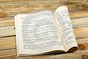 Open book, Sheet Music. Musical Notes on a white wooden table. Background.