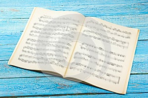 Open book, Sheet Music. Musical Notes on a white wooden table. Background.