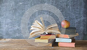 Open book and stack of books with chalk board and red apple.Back to school, education, learn concept.