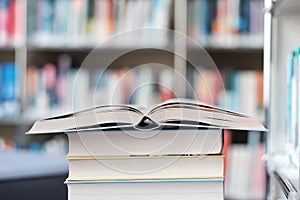 Open book on a stack of books in a library