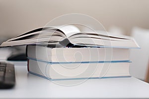 Open book on a stack of books on a table