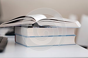 Open book on a stack of books on a table