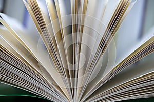 Open book, stack of hardback books on table. Top view.