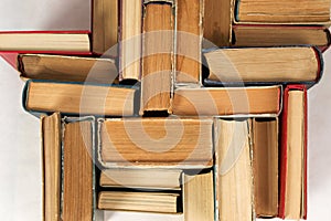 Open book, stack of hardback books on table. Top view.