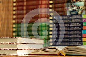 Open book and stacks of varied books many books piles on background with copyspace