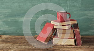 Open book, vintage hardback book and cup of coffee on green  background. Education, reading, research concept.Vintage analog film