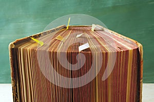 Open book, vintage hardback with bookmarks on teal background. Selective focus,close up. Education,reading, learning concept.