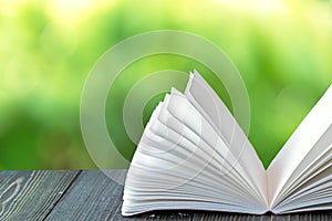 Open book on wood planks over abstract light