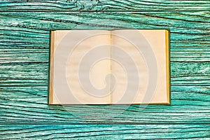 Open book on a wooden background with copy space, top view