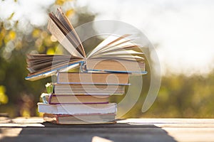 Open book on wooden table on natural background. Soft focus