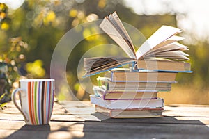 Open book on wooden table on natural background. Soft focus