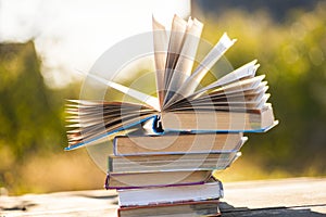 Open book on wooden table on natural background. Soft focus