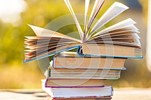 Open book on wooden table on natural background. Soft focus